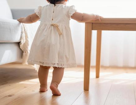 机につかまり立ちする赤ちゃん 机につかまり立ちする赤ちゃんの写真