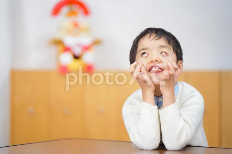 変顔で頬杖をつく男の子 男の子,人物,頬杖の写真素材