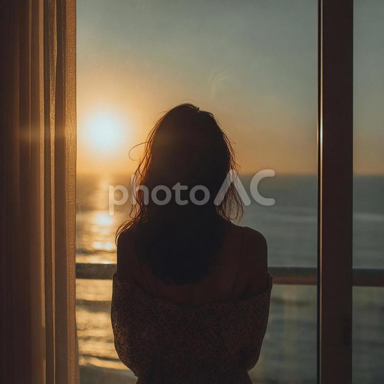 夕陽を見つめる女性の後ろ姿 女性,シルエット,後ろ姿の写真素材