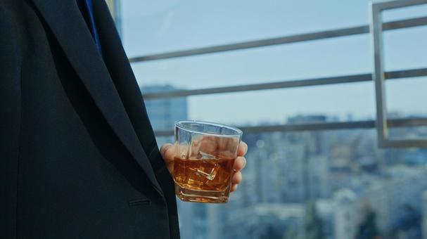 窓際でグラスを持つ左手 グラス,持つ,手元の写真素材