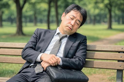 ベンチで眠る男性 ベンチで眠る男性の写真