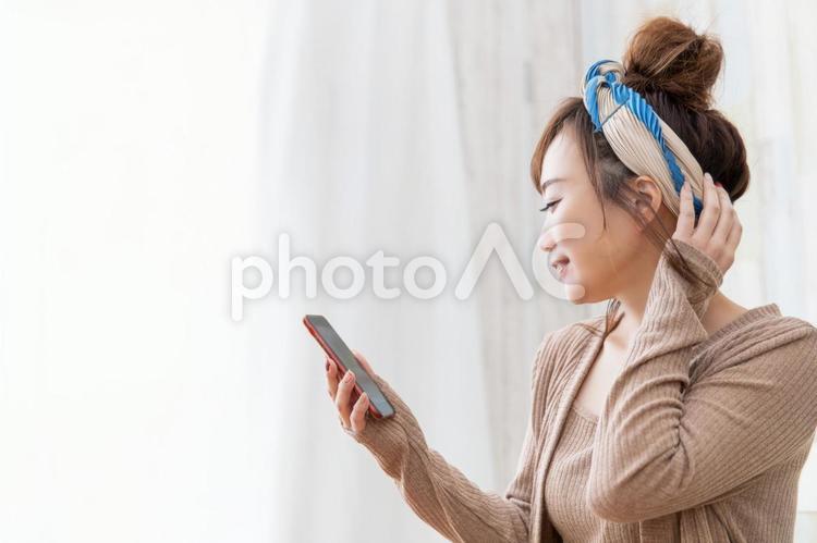 ルームウェアの女性 スマホ,読む,ステイホームの写真素材