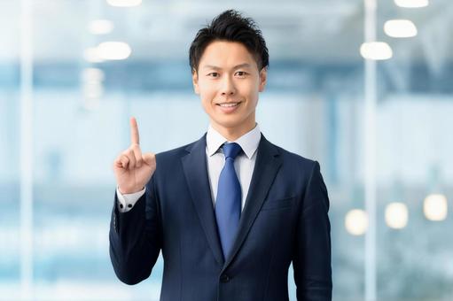 人差し指を立てて案内する男性ビジネスマン 男性,案内,笑顔の写真素材