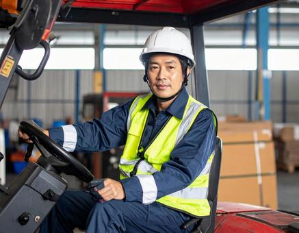 フォークリフトを運転する男性作業員の写真