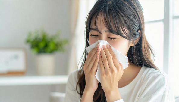ティッシュで鼻をかむ日本人の若い女性 ティッシュで鼻をかむ日本人の若い女性の写真