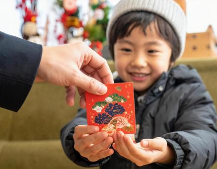 正月にポチ袋でお年玉をもらって喜ぶ子供 正月にポチ袋でお年玉をもらって喜ぶ子供の写真