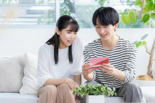 リビングでくつろぐ若いカップル リビングでくつろぐ若いカップル 夫婦,カップル,リビングの写真素材