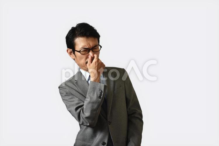 鼻をつまむビジネスマン 臭う,生乾き,加齢臭の写真素材