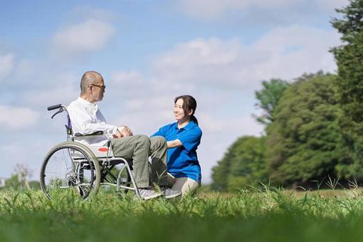 Elderly people and caregivers having a conversation on the lawn, senior citizens, wheelchair, nurses, JPG