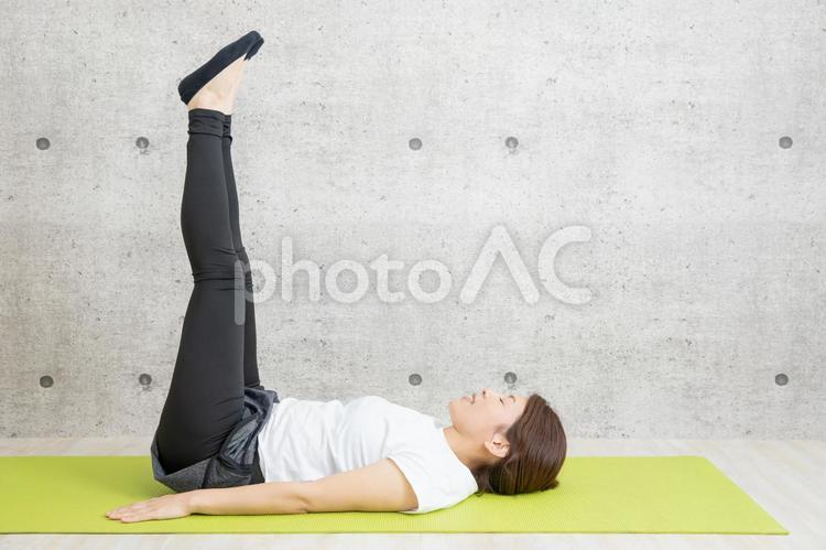 筋トレをする女性 レッグレイズ,脚上げ,足上げの写真素材