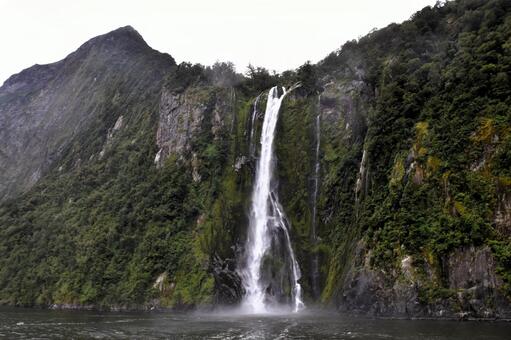 緑豊かな崖から海へと流れ落ちる壮大な滝﻿ 滝,崖,海の写真素材