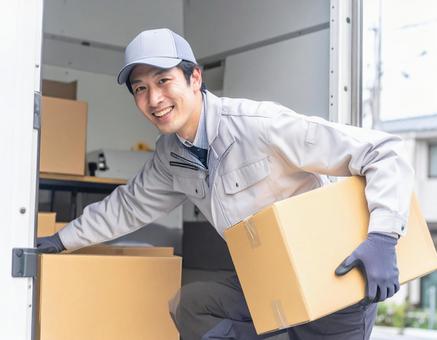 トラックから荷物を出す宅配男性ドライバー トラックから荷物を出す宅配男性ドライバーの写真