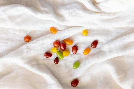 白い布の上に散らばるミニトマト 白い布の上に散らばるミニトマトの写真