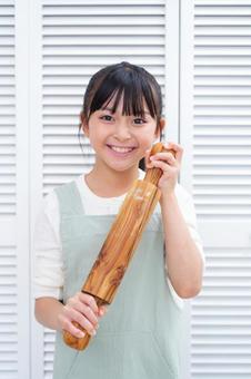 伸ばし棒を持って笑顔の女の子 女の子,日本人,めん棒の写真素材