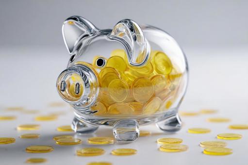 透明な豚の貯金箱に満たされた金色のコイン 透明な豚の貯金箱に満たされた金色のコインの写真