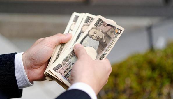 たくさんの一万円札を持つビジネスマン たくさんの一万円札を持つビジネスマンの写真