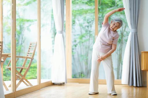 真剣な顔で右腕を伸ばす高齢女性 女性,体操,腕を伸ばすの写真素材