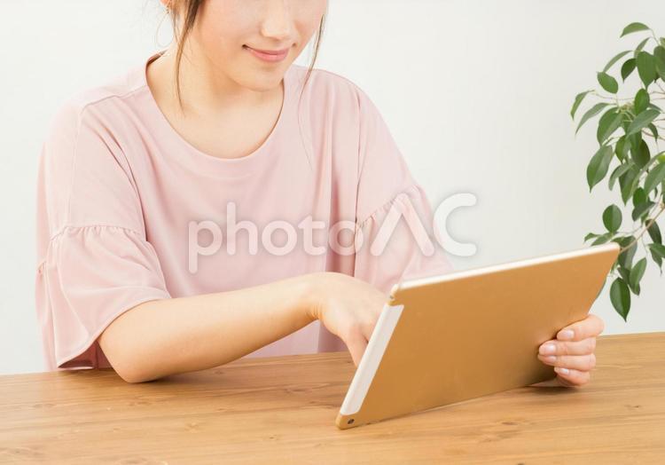 タブレットを笑顔で操作する女性 タブレット,インターネット,ネットサーフィンの写真素材