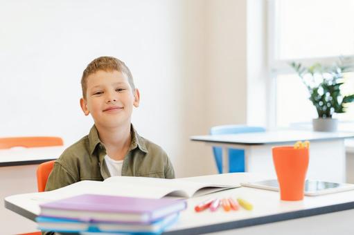 教室でカメラ目線の男の子 男の子,子ども,人物の写真素材