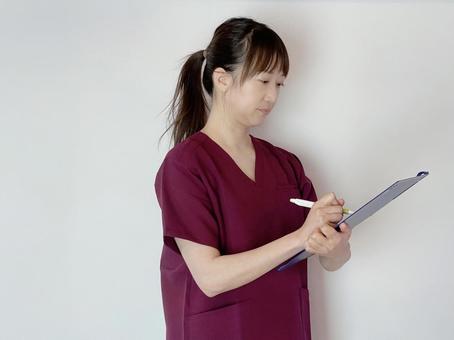メモをする看護師(医療従事者) 問診,メモ,分析の写真素材