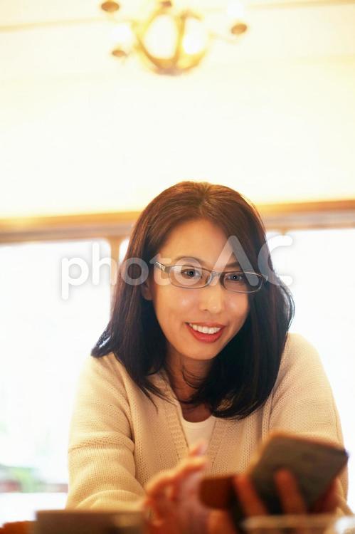 スマホをいじる眼鏡の女性 ショッピング,キャリアウーマン,スマホの写真素材