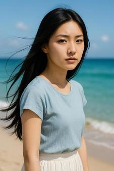 夏の海辺でシリアスな表情の女性青ブラウスの写真