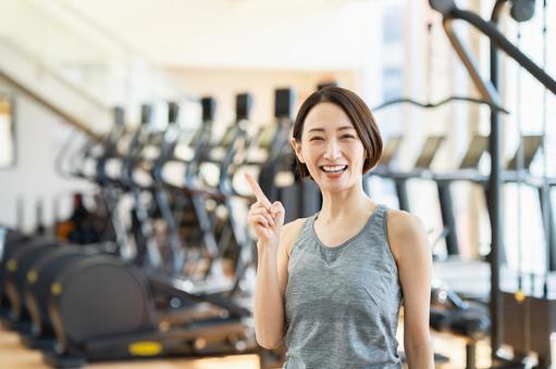 ジムでおすすめするミドルの女性 ジム,指さし,女性の写真素材