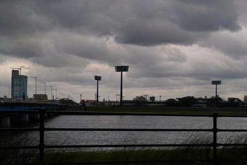 雨雲がのしかかる川べり 川,曇り,橋の写真素材