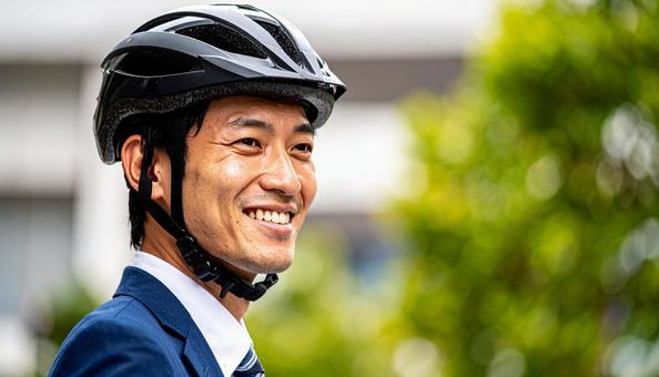 自転車用ヘルメットをかぶるビジネスマン 自転車用ヘルメットをかぶるビジネスマンの写真