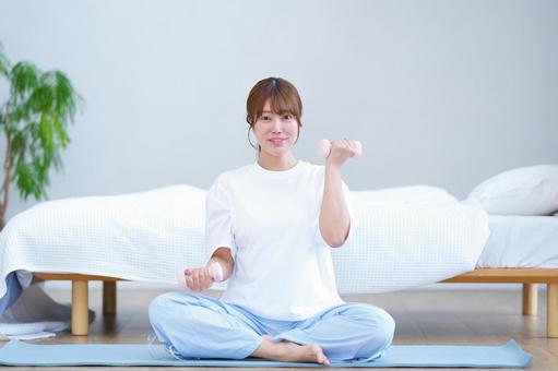 笑顔でダンベルを持つカメラ目線の女性 女性,ダンベル,持つの写真素材