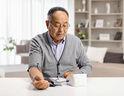 血圧を測り不安そうな表情するシニア男性 血圧を測り不安そうな表情するシニア男性の写真