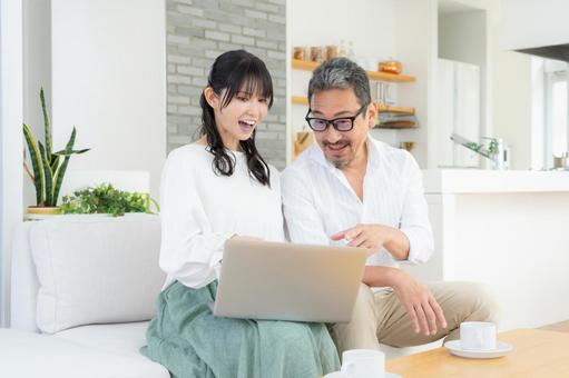 リビングでパソコンを見るミドルの夫婦 リビングでパソコンを見るミドルの夫婦 夫婦,家族,ミドルの写真素材