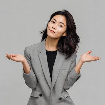 思案顔でジェスチャーを交える働く女性の写真