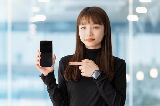 スマホの画面を指差す女性 スマホの画面を指差す女性 女性,スマホ,笑顔の写真素材