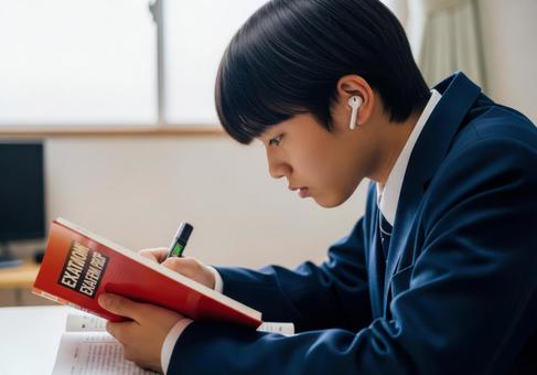 真剣に参考書を読む男子学生 真剣に参考書を読む男子学生の写真