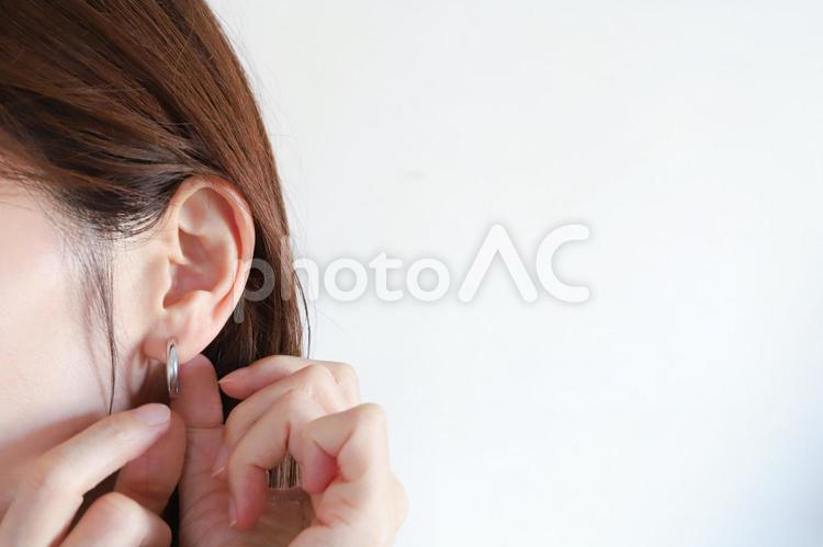 ピアスをつける女性の手元 ピアス,アクセサリー,耳の写真素材