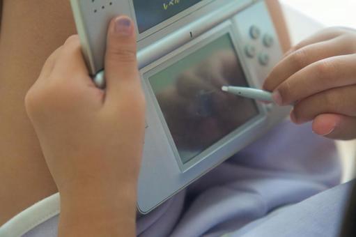 ゲームをしている娘の手元 ゲームをしている娘の手元 ゲーム,携帯ゲーム機,ポータブルゲームの写真素材