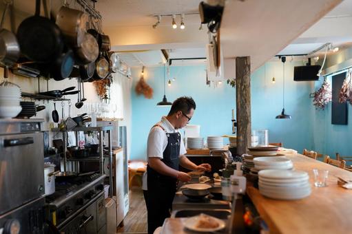 料理人がオープンキッチンで料理をする 料理人がオープンキッチンで料理をする 料理人,カフェ,キッチンの写真素材
