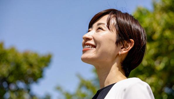 上を向いた日本女性の笑顔の横顔 上を向いた日本女性の笑顔の横顔の写真