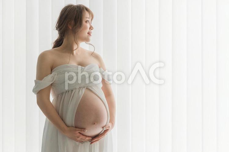 マタニティフォトの撮影をする女性（横顔） 妊婦,妊娠,マタニティフォトの写真素材