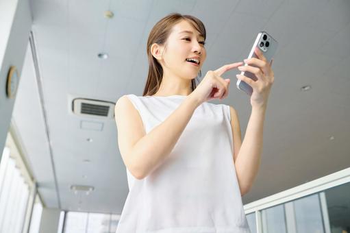 スポーツジムでスマホを見る女性 スマホ,女性,スポーツジムの写真素材