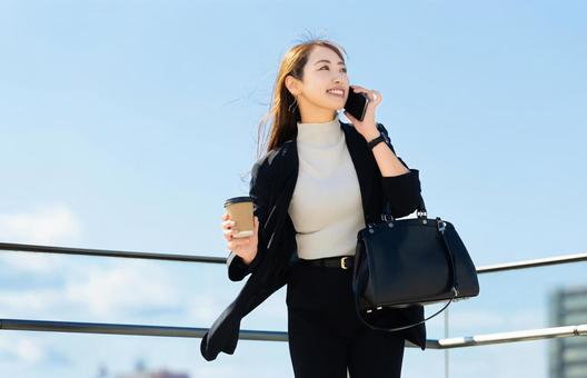 スマホで話す笑顔の女性・ビジネスウーマン 女性,スマホ,スマートフォンの写真素材