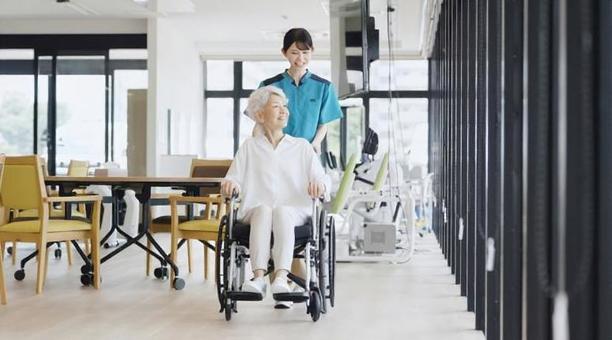 車椅子で散歩をする高齢者と介護士 車椅子で散歩をする高齢者と介護士 高齢者,車椅子,介護士の写真素材