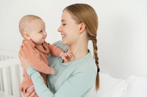 笑顔で抱っこしている子供を見る三つ編み女性 笑顔で抱っこしている子供を見る三つ編み女性 親子,母子,赤ちゃんの写真素材