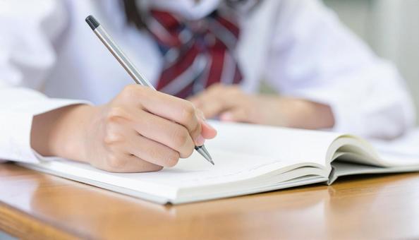 ノートに記入する日本人中学生の女の子の手 ノートに記入する日本人中学生の女の子の手の写真