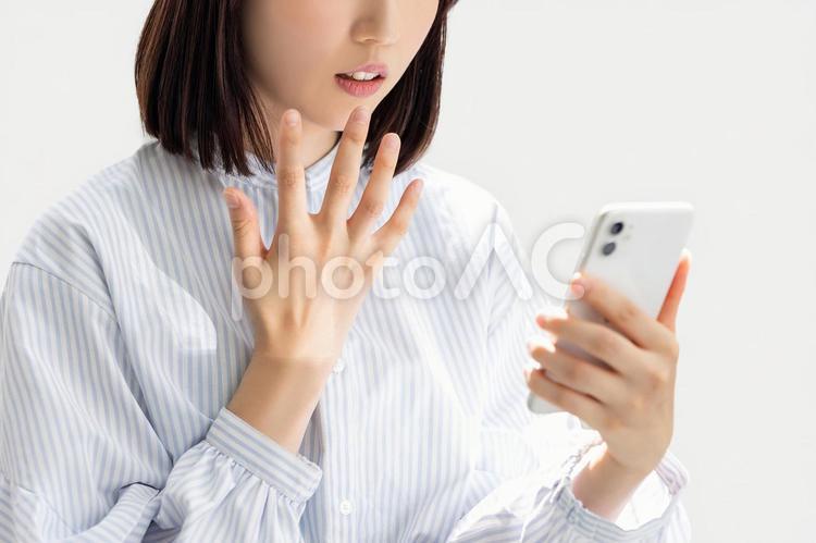 スマホの画面を見て驚く女性 女性,スマホ,人物の写真素材