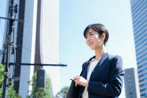 オフィス街で働く若いビジネスウーマン オフィス街で働く若いビジネスウーマンの写真