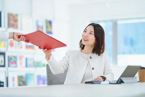仕事中に同僚と会話する女性 仕事中に同僚と会話する女性 ビジネス,女性,会話の写真素材