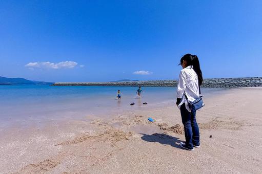 ＜素材＞夏の海で子供が遊ぶ姿を見守る母 女性,子供,男性の写真素材