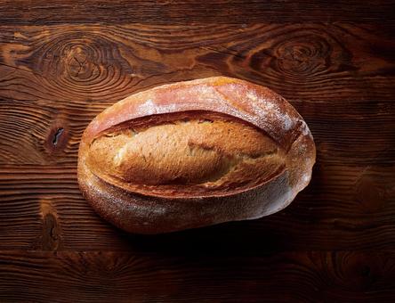 木のテーブルに置いたフランスパン 木のテーブルに置いたフランスパンの写真